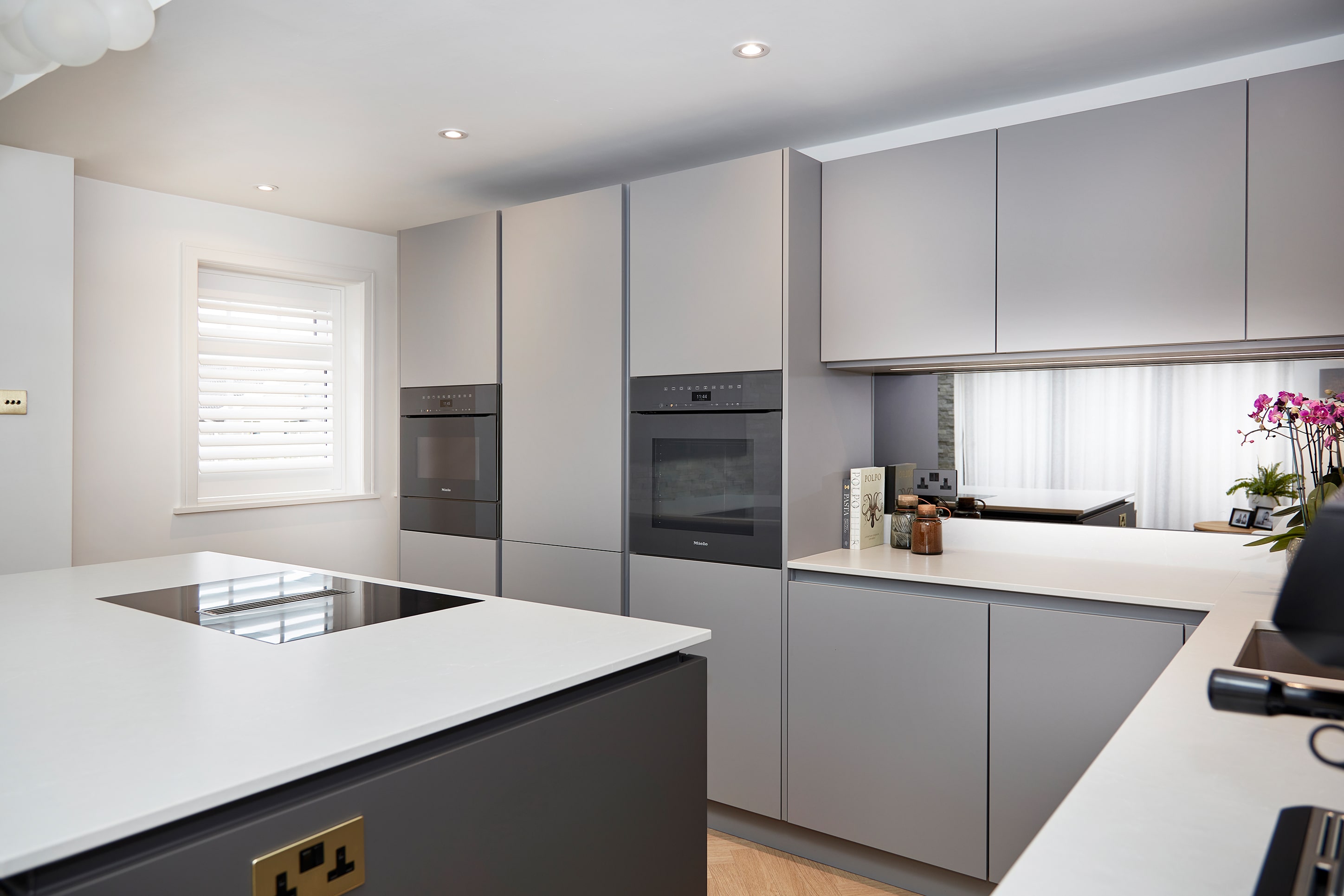 Miele pyrolytic oven, combination microwave and warming drawer built into light grey handleless cabinetry, Calverley, Leeds.