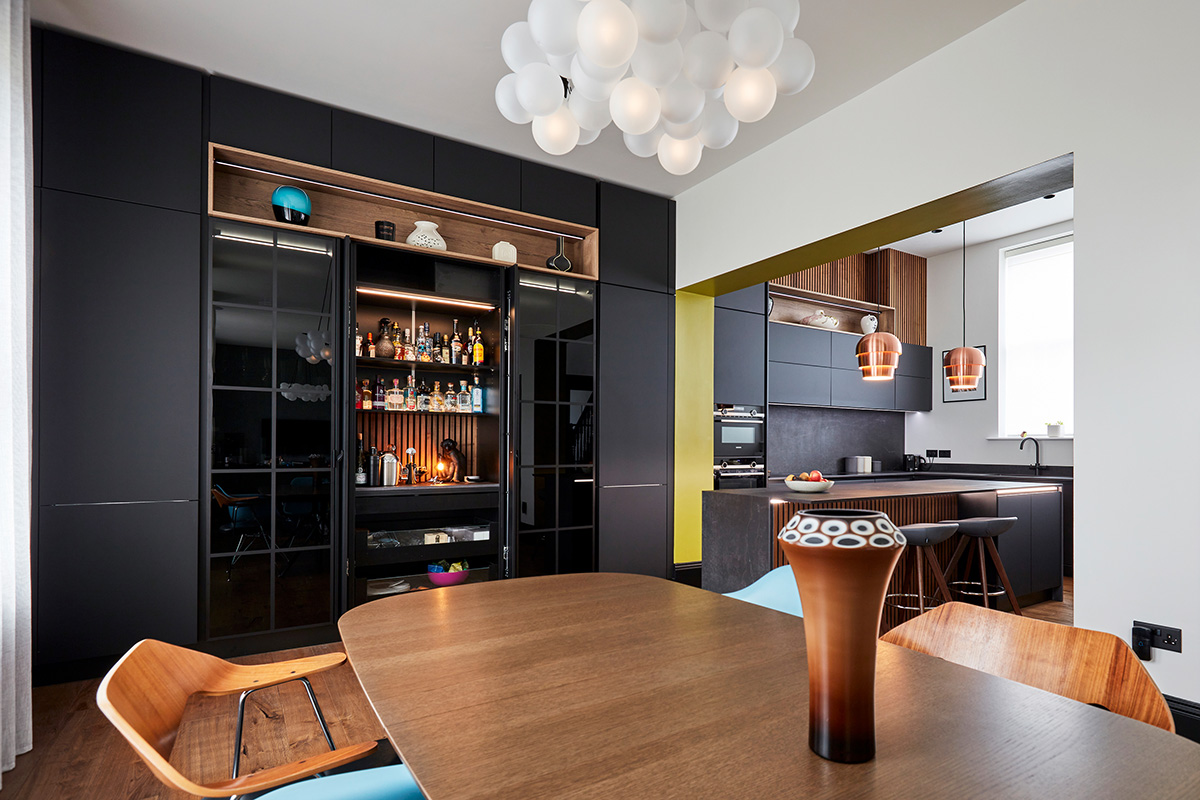Open drinks cabinet in matt black kitchen