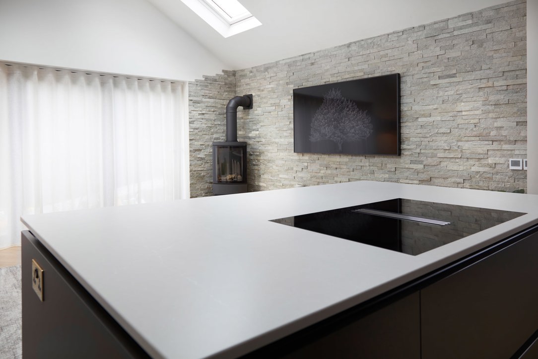 Miele venting induction hob in a kitchen island beneath a vaulted ceiling and skylight, with no overhead extractor, Calverley, Leeds.